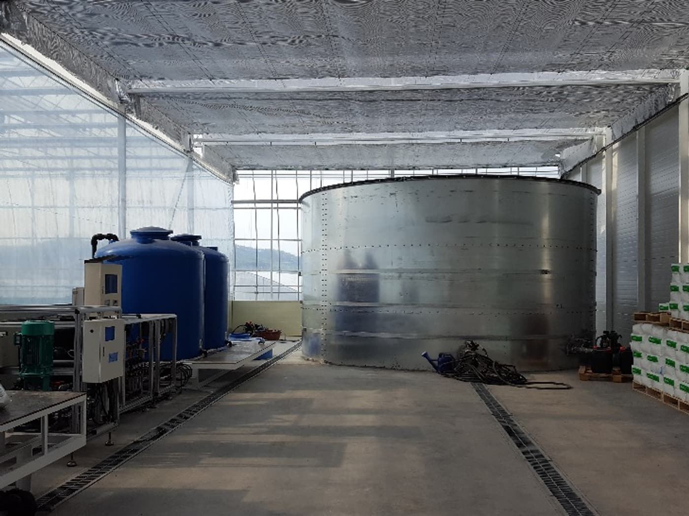 O2MOS oxygen dissolution system installed beside nutrient solution tanks in a commercial greenhouse